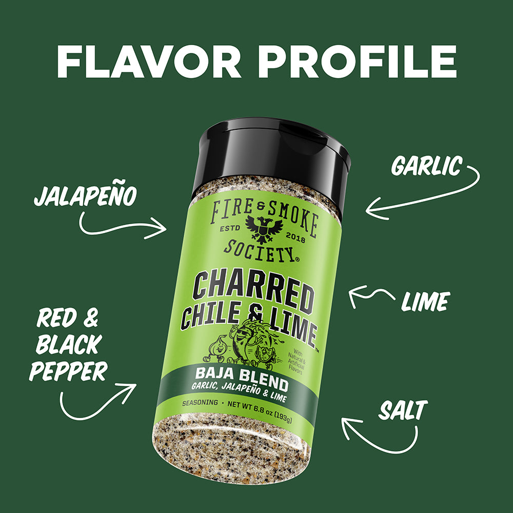 A bottle of Fire & Smoke Society Charred Chile & Lime seasoning is centered on a dark green background with white text and arrows labeling flavor profile components: jalapeño, garlic, lime, red & black pepper, and salt.