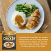 Plate of roasted chicken, mashed potatoes with gravy, and green beans on a wooden table with a packet of Fire & Smoke Society Chicken Gravy.