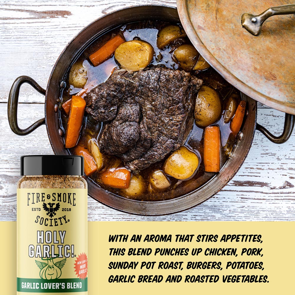 Fire and Smoke Society Holy Garlic! Garlic Lover's Blend seasoning bottle shown next to a rustic cooking scene of a pot of meat and potatoes, with promotional text on a light wood background.