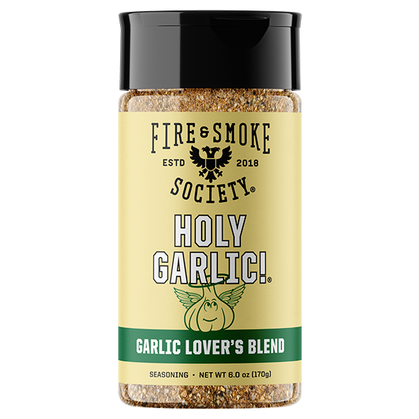 A bottle of Fire & Smoke Society Holy Garlic! Seasoning on a plain white background. The product features a pale yellow label with a black cap, showing the brand logo and a graphic of a smiling garlic bulb.