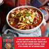 Bowl of chili with toppings held by a person, featuring a Fire & Smoke chili package.