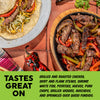 Overhead food photography of grilled steak with onion and peppers, alongside a plated fajitas and a red chili pepper on a terracotta tile background. A bright green banner at the bottom reads 'TASTES GREAT ON' with descriptive text about the food.