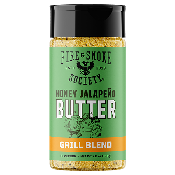 A bottle of Fire & Smoke Society Honey Jalapeño Butter Grill Blend seasoning, featuring a green label with a black cap and orange accent band, on a white background.