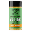 A bottle of Fire & Smoke Society Honey Jalapeño Butter Grill Blend seasoning, featuring a green label with a black cap and orange accent band, on a white background.