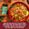 A jar of Lucky Lucky Sweet and Smoky Spice Blend sits beside a large red bowl filled with shrimp and rice on a wooden table. A text banner at the bottom describes the flavor profile.
