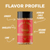 A spice blend jar labeled 'Noodle House Asian Noodle Blend' centered on a tan background with white text callouts reading Ginger, Shallots, Lime, Korean Chili Flakes, and Sesame Seeds pointing to flavor ingredients.