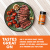 steak slices on a green plate with roasted garlic, cherry tomatoes, and rosemary, next to a bottle of Roasted Garlic seasoning, on a white striped background with an orange text banner at the bottom.