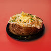 Baked potato with toppings on a red background