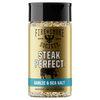 A bottle of Fire & Smoke Society Steak Perfect Garlic & Sea Salt seasoning, featuring a gold label with a black cap and a blue accent band, set against a plain white background.