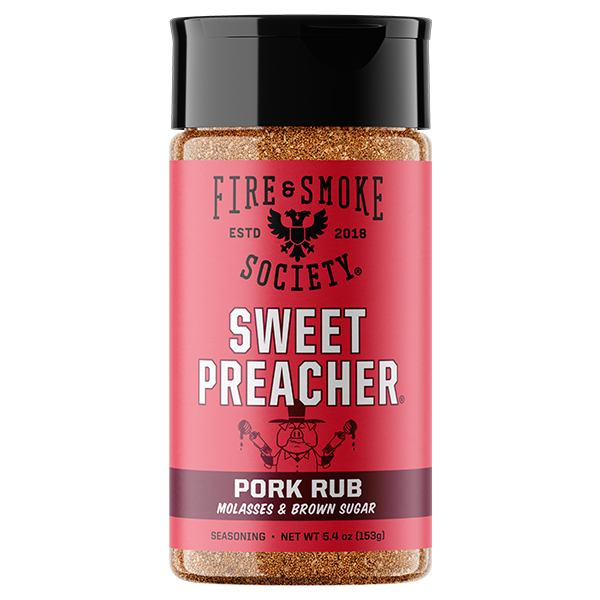A bottle of Fire & Smoke Society Sweet Preacher Pork Rub seasoning, featuring a bright pink label with white and black text, a black cap, and visible brown spice granules inside, set against a plain white background.