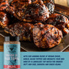 Grilled chicken pieces on a tray with a bottle of 'Mayor of Rub Town' BBQ rub from Fire & Smoke Society.