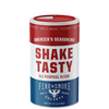 A cylindrical canister of Shake Tasty All-Purpose Blend seasoning by Fire & Smoke Society, featuring a red, white, and blue label with a red lid, set against a plain white background.