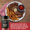 Steak, fries, and ketchup on a plate with Steak King seasoning bottle.