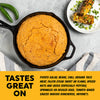 A cast iron skillet filled with golden cornbread sits on a light gray stone surface, with green jalapeños on the left and a plate of grilled corn with chopped green onions on the upper right. A bold text banner at the bottom reads 'TASTES GREAT ON' with descriptive food pairings below.