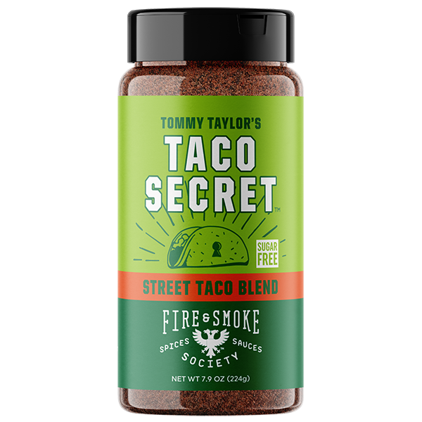 A bottle of Tommy Taylor's Taco Secret Street Taco Blend seasoning by Fire & Smoke Society, featuring a green and orange label with a black cap