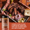Platter of barbecue meats with a jar of 'Fire & Smoke Society' Texas Hickory BBQ Rub on a wooden surface.