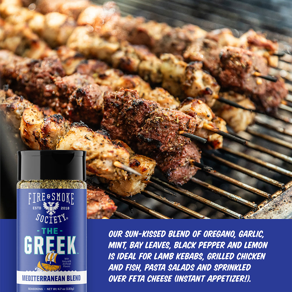 a bottle of The Greek Seasoning in front of skewers of grilled meat on a grill