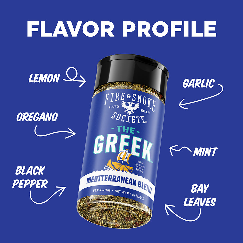A seasoning shaker bottle labeled 'The Greek' by Fire & Smoke Society, centered on a blue background with white text and arrows pointing to flavor notes: lemon, oregano, garlic, mint, bay leaves, and black pepper.