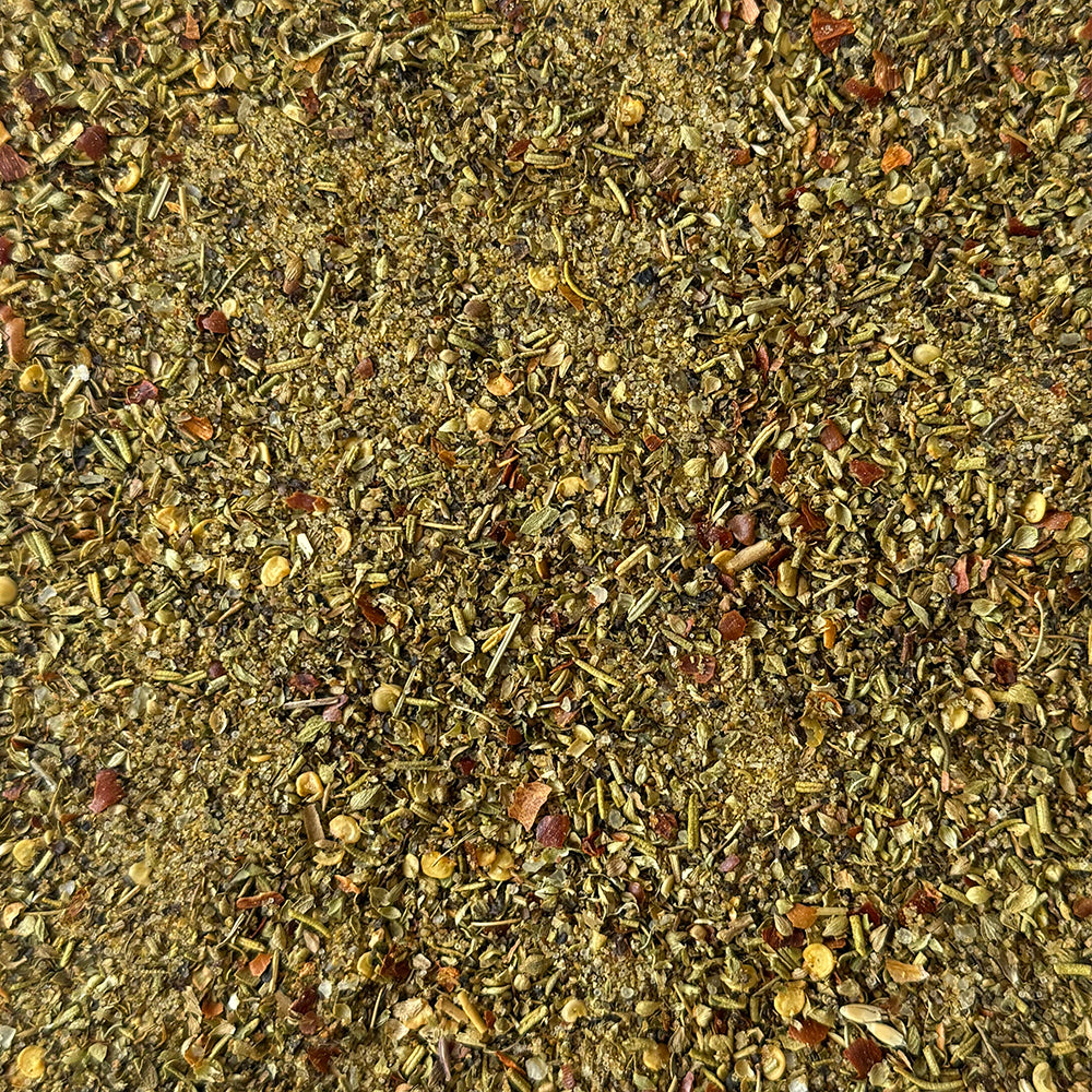 A bottle of Fire & Smoke Society 'The Greek' Mediterranean Blend seasoning, featuring a blue label with white and teal text and a black cap, on a white background.