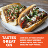 Two gourmet hoagies on a white plate, topped with chopped herbs, white sauce, and red peppers, set on a wooden table with an orange text banner at the bottom.