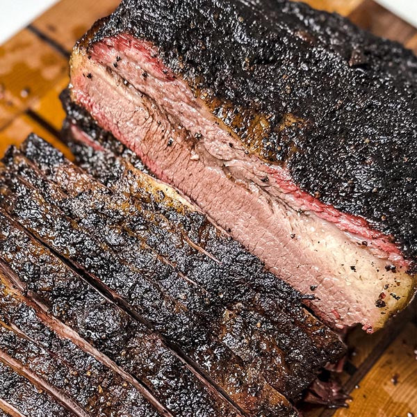 Sliced smoked brisket on a wooden cutting board